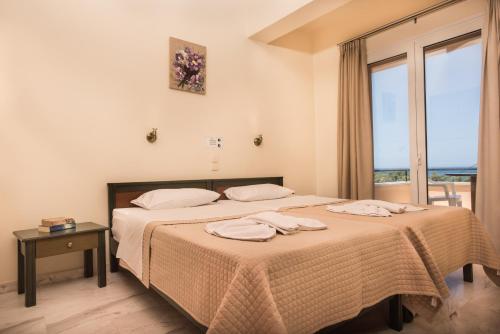 a hotel room with a bed and a table at Mythos Beach Hotel Apartments in Maleme