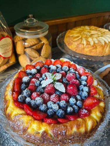 a fruit pie with berries on top on a table at Art Hotel Pietrasanta in Pietrasanta