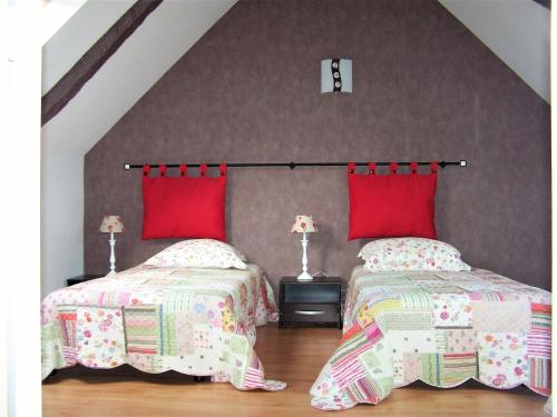 two beds in a attic bedroom with red pillows at Holiday Home in Huelgoat near Monts d'Arrée in Huelgoat