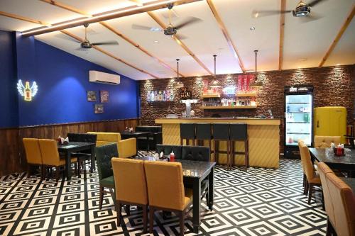a restaurant with tables and chairs and a bar at Hotel Golden Fern in Patiāla