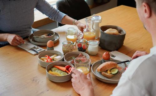 a group of people sitting at a table with food at Puitalm Apartments & SPA by Peak Stay in Arzl im Pitztal