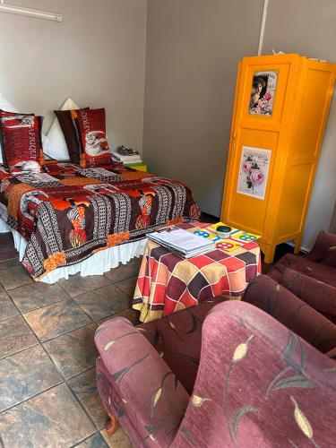 a room with two beds and a couch and a chair at The Angel River Villa in Meyerton