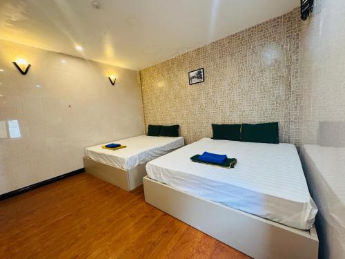 two beds in a small room with wooden floors at Sword Lake hostel in Hanoi