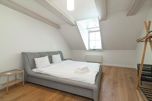 een slaapkamer met een bed met witte lakens en een raam bij Spacious 3 BDR apartment in Old Town in Vilnius