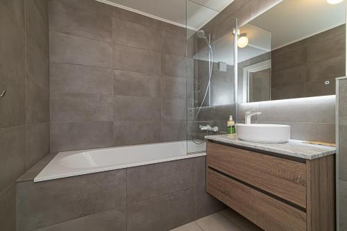 een badkamer met een bad en een wastafel en een ligbad bij Spacious 3 BDR apartment in Old Town in Vilnius