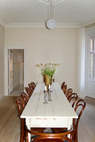 a dining room with a white table with chairs at SJ Apartment in Aarhus