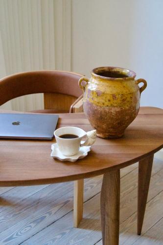 a table with a cup of coffee and a pot on it at SJ Apartment in Aarhus
