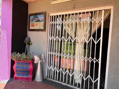 a front door of a house with a fence at The Angel River Villa in Meyerton