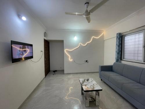 a living room with a couch and a tv at Fernhouse 2bhk in Pune