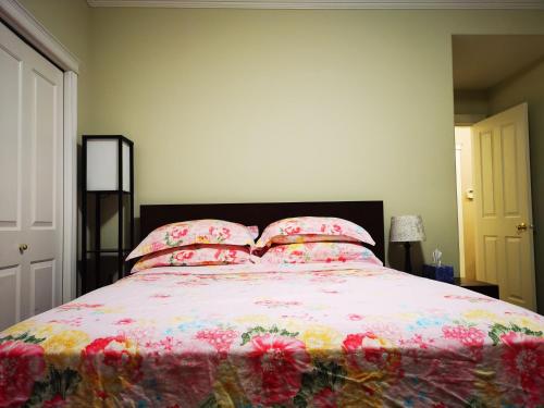 a bedroom with a large bed with pink sheets and pillows at Eagle's House, Room #1 in Victoria