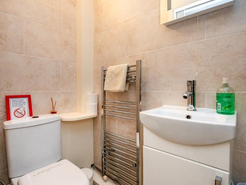 a bathroom with a toilet and a sink at Wood Bank Studio Apartment in Holmfirth