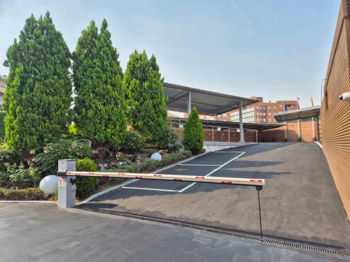 a tennis court in a parking lot next to a building at Hotel Reston Valdemoro in Valdemoro