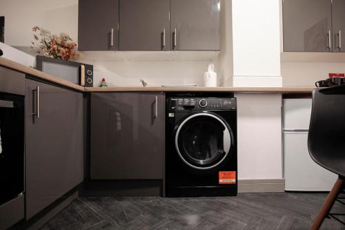 a kitchen with a washing machine in a counter at Bartlam Place, Sleeps 6, Central Oldham - By NMB Property in Oldham