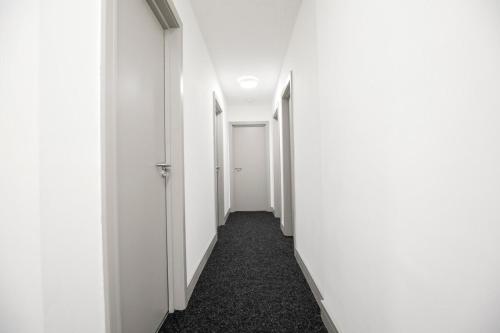 an empty corridor with white walls and a hallway at Bartlam Place, Sleeps 6, Central Oldham - By NMB Property in Oldham