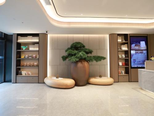 a large vase with a tree in a room at JI Hotel Beijing Yanqing Tower Wanda Plaza in Yanqing