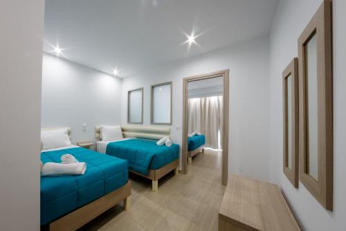 a room with two beds and a mirror at Caretta Paradise Resort & WaterPark in Tragaki
