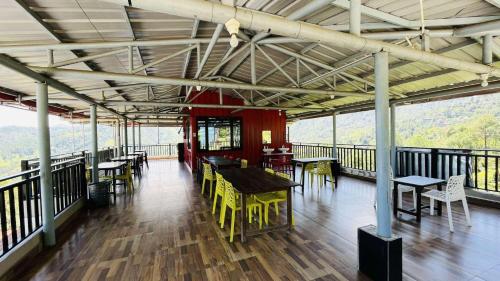 a restaurant with tables and chairs on a balcony at Trishul Regency Kausani in Kausani
