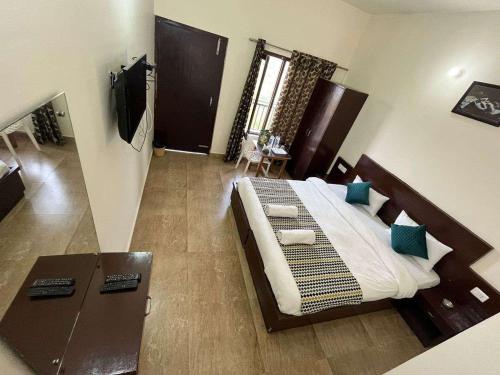 a bedroom with a large bed and a desk in it at Trishul Regency Kausani in Kausani