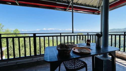 a table with a plate of food on a balcony at Trishul Regency Kausani in Kausani