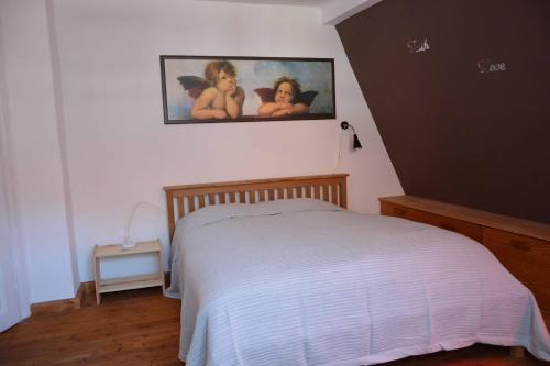 a bedroom with a bed and a painting on the wall at FeWo Rhoen-Thal in Gersfeld