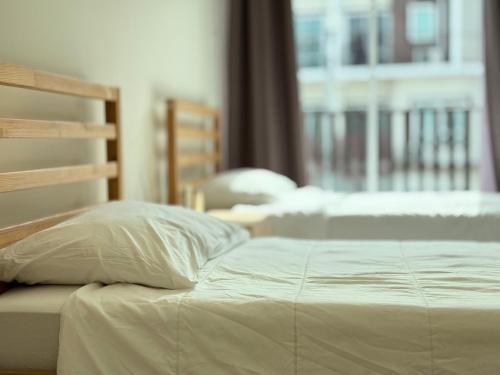 a bed with white sheets and pillows in a bedroom at Jira cozy room Suvarnabhumi Airport 15mins in Lat Krabang