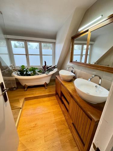 a bathroom with two sinks and a bath tub at La Chanterelle in Wavre