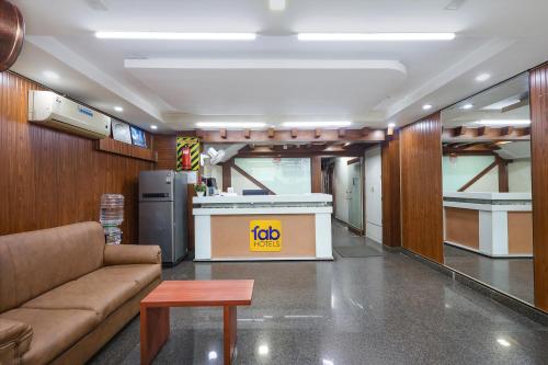 a living room with a couch and a refrigerator at FabHotel RKH Skyline Residency in Chennai