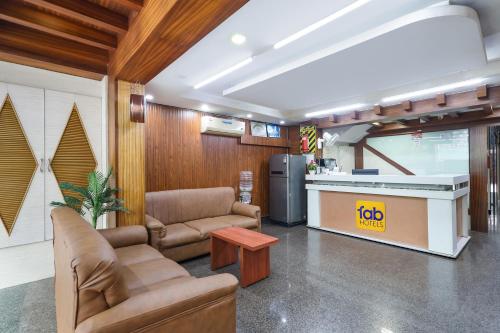 a living room with two couches and a kitchen at FabHotel RKH Skyline Residency in Chennai