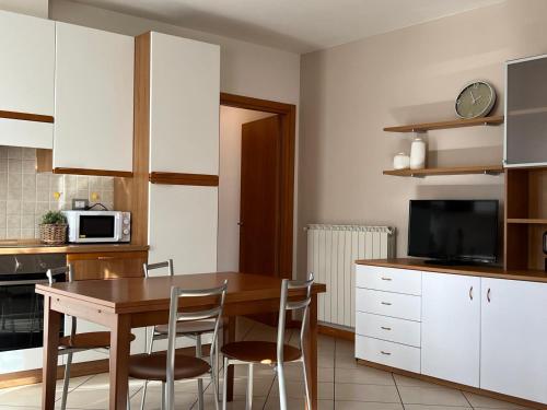a kitchen with a table and chairs and a microwave at La Valle Maggiore Apt in Villa di Tirano
