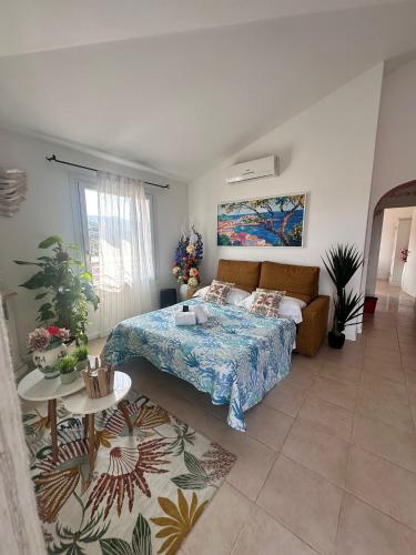 a bedroom with a bed and a couch and a table at Ea Bianca Vibes in Arzachena