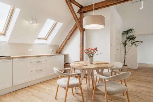 a kitchen and dining room with a table and chairs at Apartamenty SWAN in Gliwice