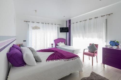 a bedroom with two beds with purple and white pillows at SunriseDreamHouse in Ponta Delgada