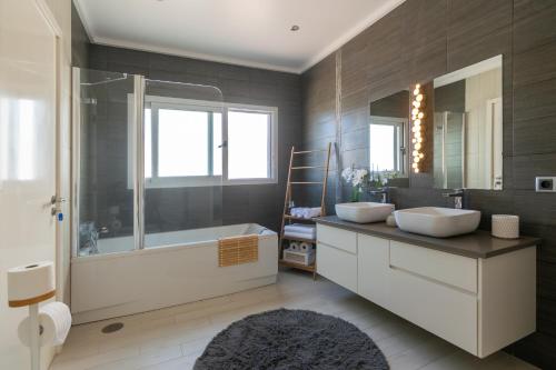 a bathroom with two sinks and a bath tub at SunriseDreamHouse in Ponta Delgada