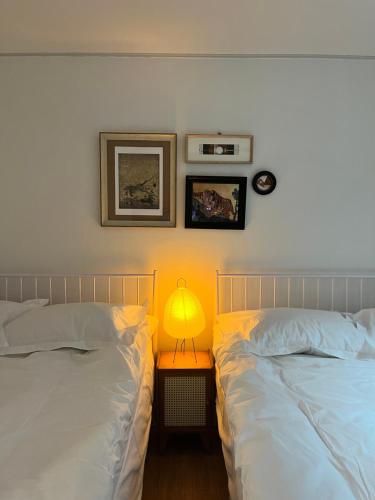 a bedroom with two beds and a lamp on a table at 소소 하우스 in Seoul