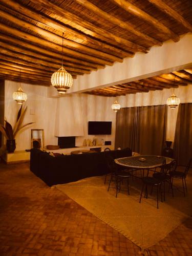 a large room with a table and chairs and lights at Modern oasis near Palmeraie - Dar Tal in Douar Oulad Ali