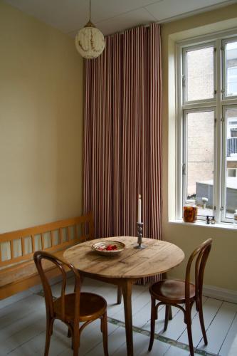 a dining room table with two chairs and a window at SJ Apartment in Aarhus