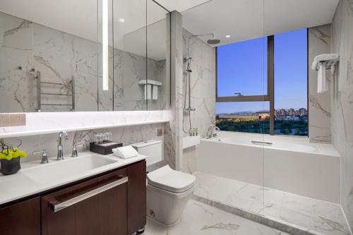Un baño con lavabo, inodoro y ducha. en Ascott Sunland Shanghai, en Shanghái