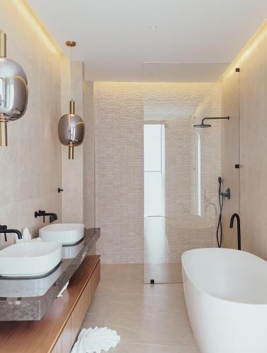 a white bathroom with two sinks and a tub at villaSAMU in Choeng Mon Beach