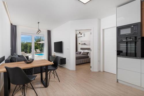 a living room and dining room with a table and chairs at Apartment in Villa Marealto with pool, garage and seaview in Ičići