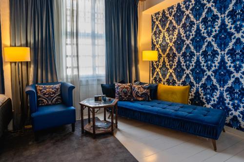 a living room with a blue couch and two chairs at Librije's Hotel in Zwolle