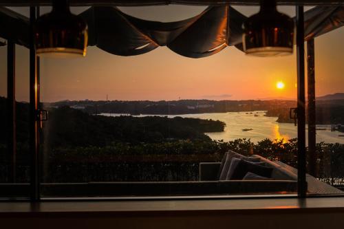 a view of a river from a window with the sunset at Shima Kanko Hotel The Classic in Shima