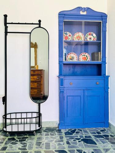 a blue hutch with a mirror in a room at Villa Kastrouna, with private heated jacuzzi in Symi