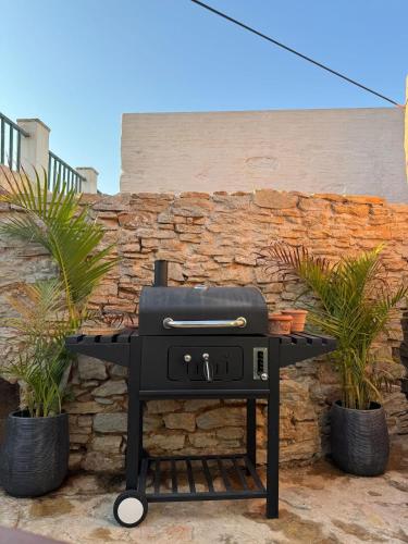 a black grill sitting in front of a stone wall at Villa Kastrouna, with private heated jacuzzi in Symi