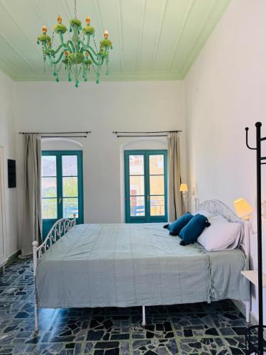 a bedroom with a bed with blue pillows on it at Villa Kastrouna, with private heated jacuzzi in Symi