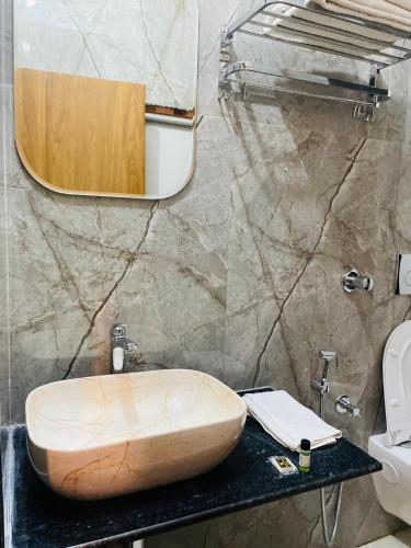 a bathroom with a sink and a mirror on a counter at WILD RIDGE SARISKA RESORT in Mairh