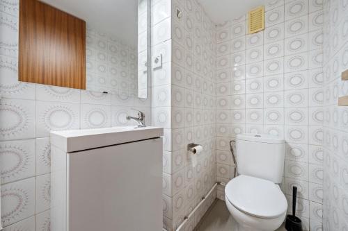 a white bathroom with a toilet and a sink at Tirreno 304 in La Pineda