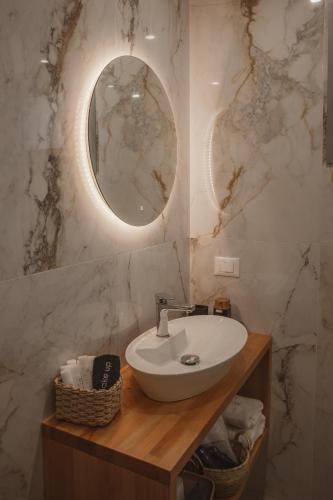 a bathroom with a sink and a mirror at QUERCUS Boutique Living in Valanidorachi