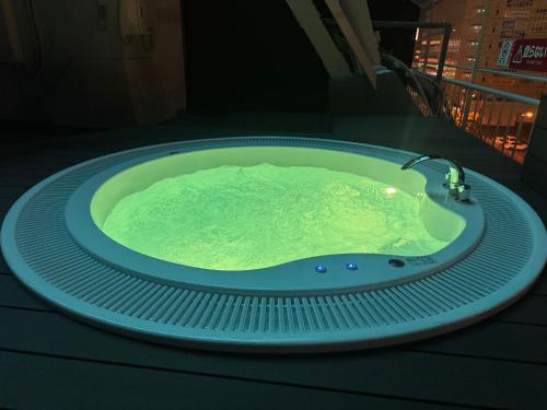 a jacuzzi tub with a faucet on a table at Capsule Hostel Beppu Tower in Beppu