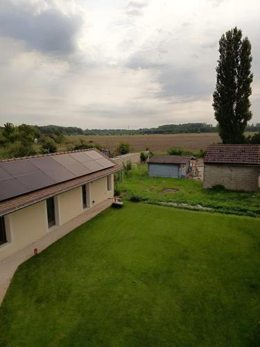 a view of a yard with a house and a green lawn at Les Hôtes des Maillets 