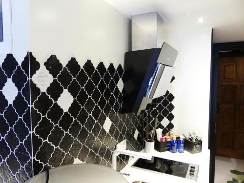 a bathroom with a black and white patterned wall at Casa Hermes in Villajoyosa